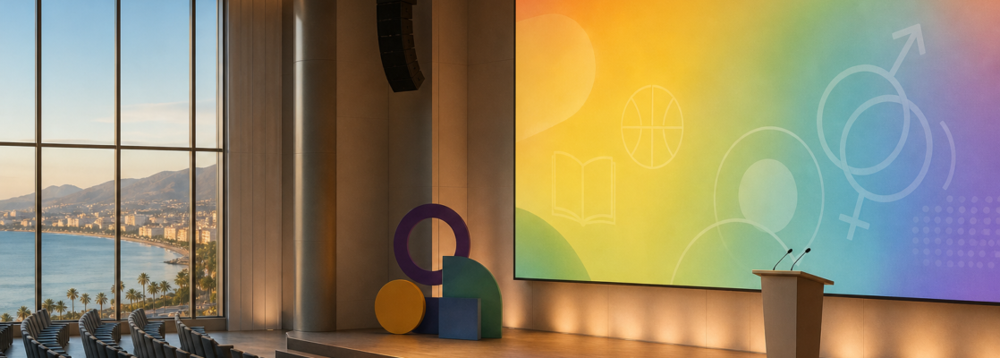 Auditorio vacío con escenario, colores alusivos al colectivo LGTBI y una vista lateral de la costa de Torremolinos.